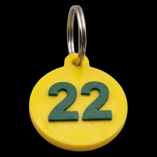 Chaveiro 22: redondo, amarelo, com o número 22 em verde